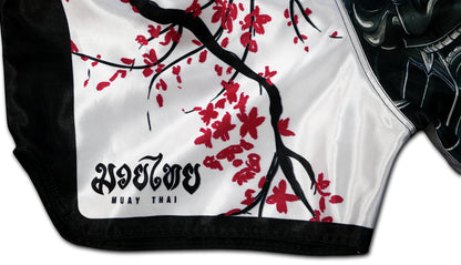 Close-up of the Sakura Muay Thai Shorts side detail, featuring sakura blossoms and traditional Muay Thai text, handcrafted in Thailand.