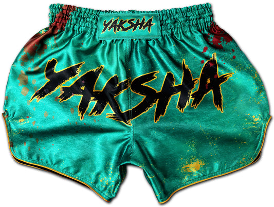 YAKSHA Muay Thai Shorts GRUNGE jade green with gold trim and black logo, featuring dried blood and paint splatter design, handmade in Thailand.