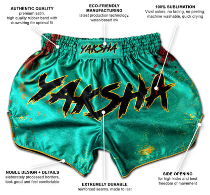 YAKSHA Muay Thai Shorts GRUNGE jade green with gold trim, showing labeled features such as premium satin, eco-friendly sublimation, reinforced seams and side openings.