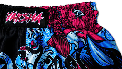 Detail picture of YAKSHA Muay Thai Shorts Luk Krʉng Black Oni waistband with red koi fish, blue waves, and pink YAKSHA logo patch, handmade in Thailand.