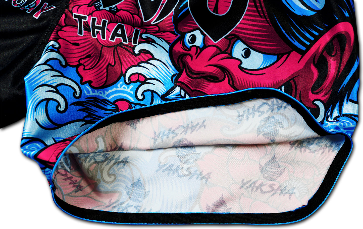 Inside view of YAKSHA Muay Thai Shorts Luk Krʉng Black Oni showing YAKSHA logo inner lining, detailed stitching, and colorful Oni demon artwork, handmade in Thailand.