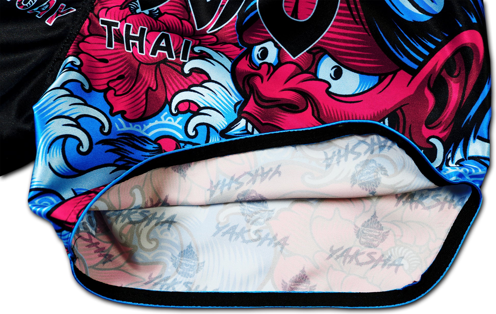 Inside view of YAKSHA Muay Thai Shorts Luk Krʉng Black Oni showing YAKSHA logo inner lining, detailed stitching, and colorful Oni demon artwork, handmade in Thailand.