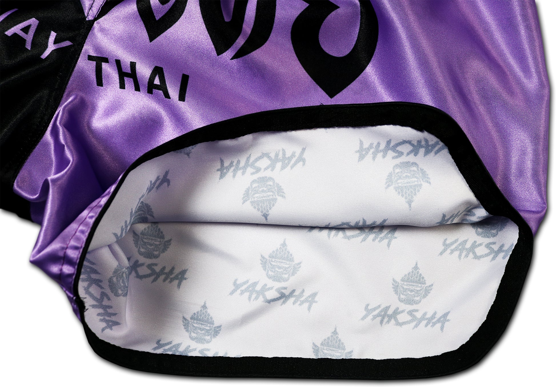 YAKSHA Luk Krung Muay Thai Shorts Black Lavender – detail picture of side opening revealing exclusive all-over YAKSHA signature logo print on the interior satin, a premium branding detail that sets these shorts apart
