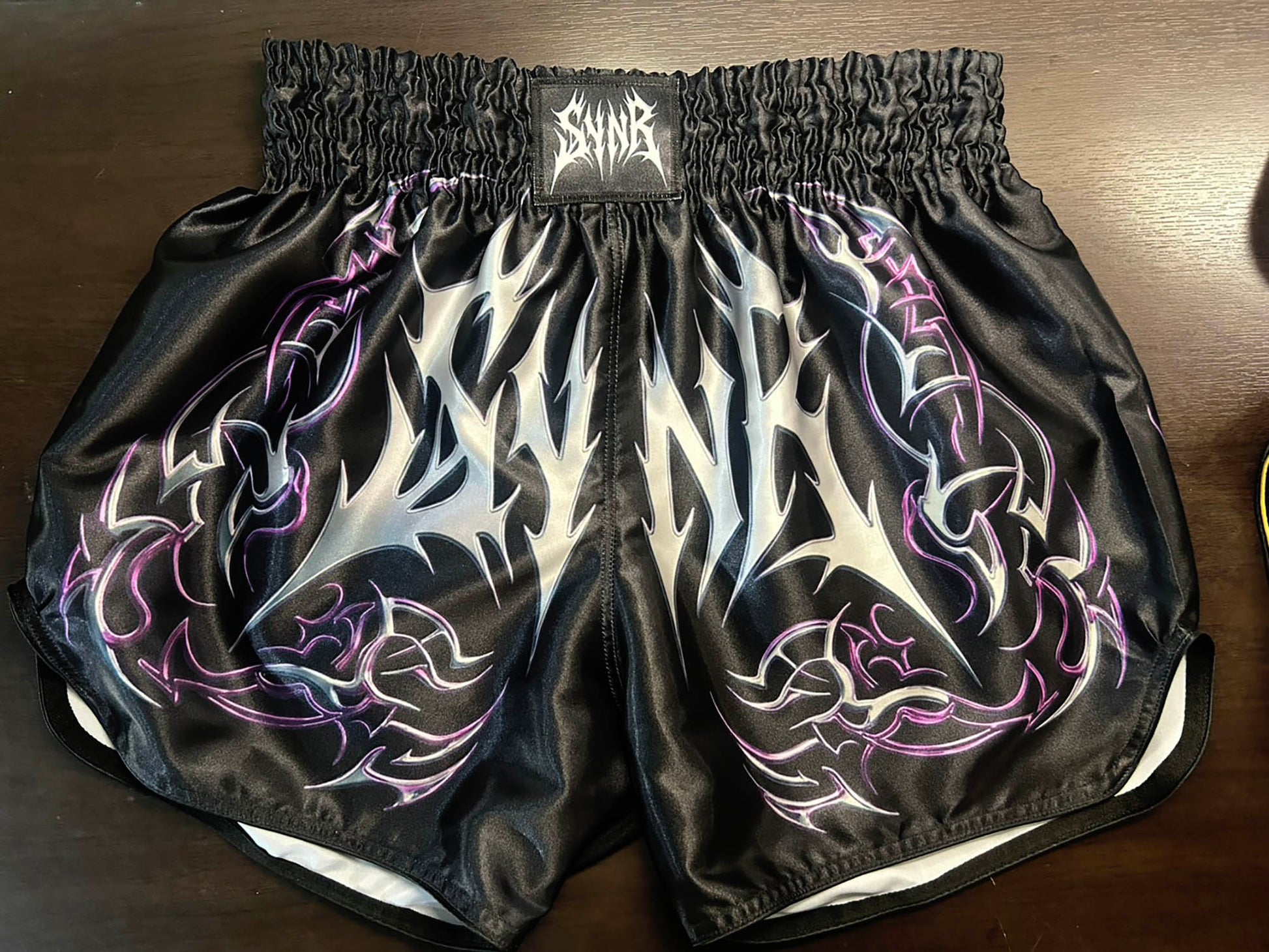 Custom-made Thaiboxing Shorts Black with Silver and Purple Tribal Flame Print and SYNR Logo Patch, Gothic Street Style Design