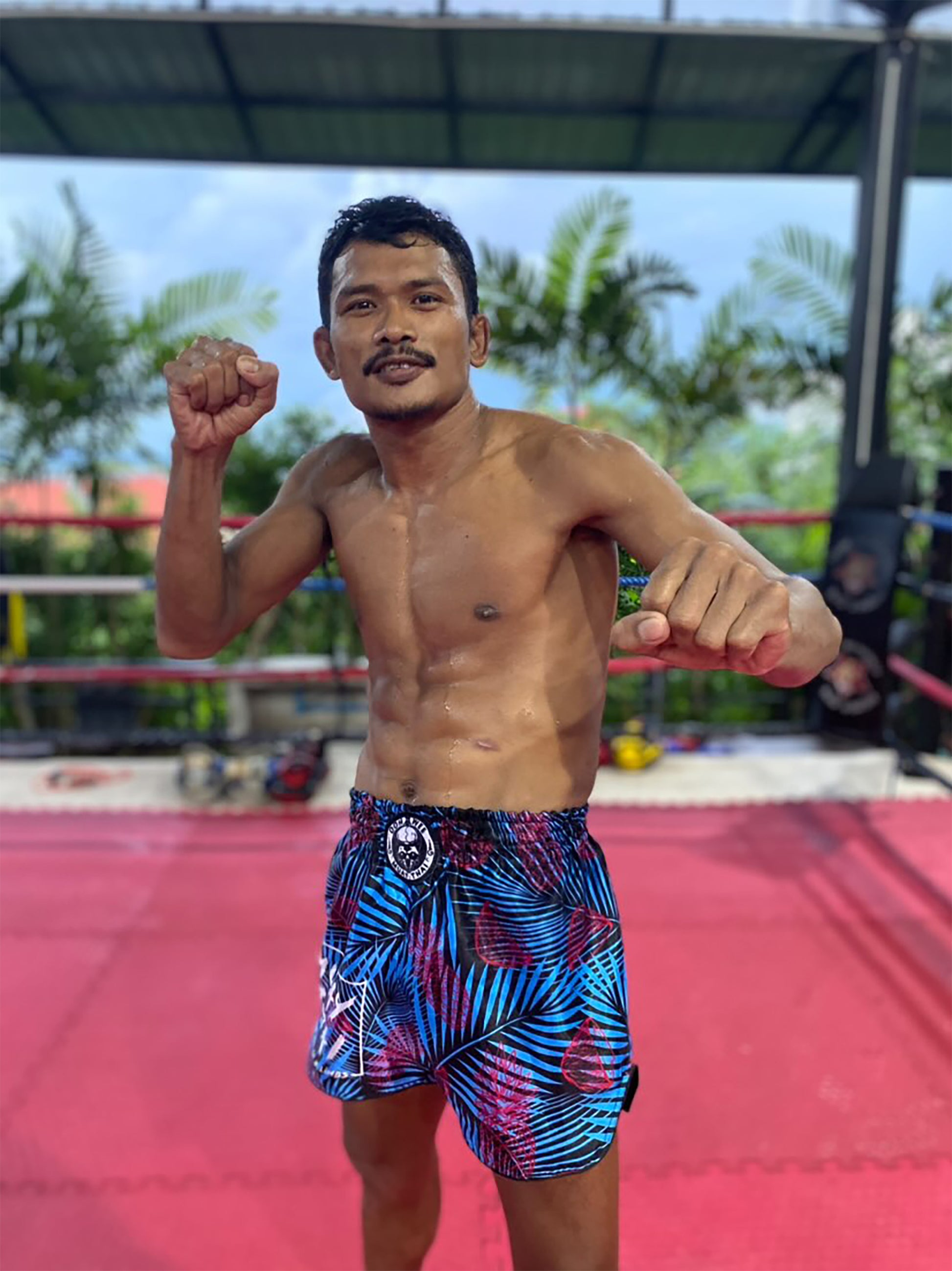 Thai fighter wearing OOWEE Tropical Thai Boxing Shorts in black blue and pink during Muay Thai training in Thailand