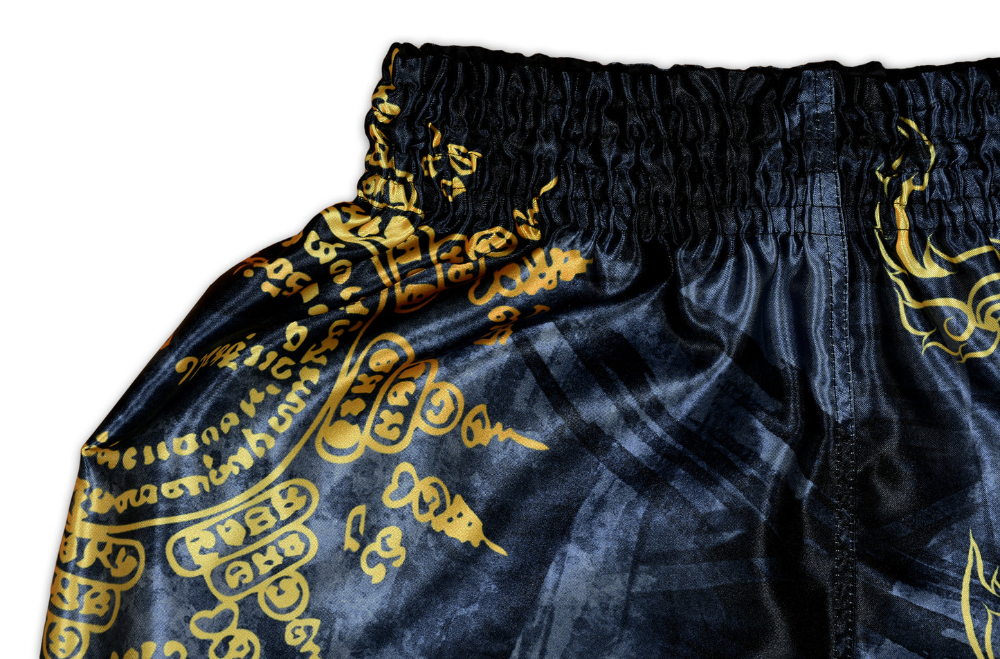 Close up of black elastic waistband and gold Sak Yant script on Phaya Naga fight shorts