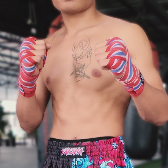 YAKSHA Black Oni Muay Thai shorts in action by male fighter showing kicks, teeps and punches on a heavy bag