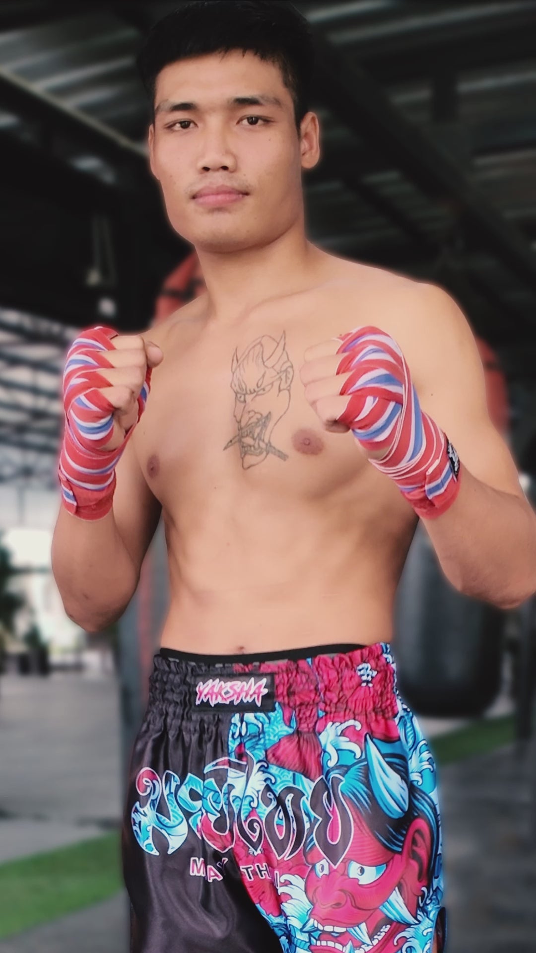 YAKSHA Black Oni Muay Thai shorts in action by male fighter showing kicks, teeps and punches on a heavy bag