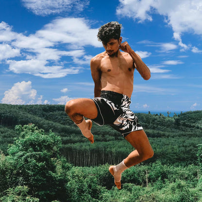 famous instragram influencer BAO wearing Tribal Samurai Muay Thai Boxing Shorts in black and white during high knee kick