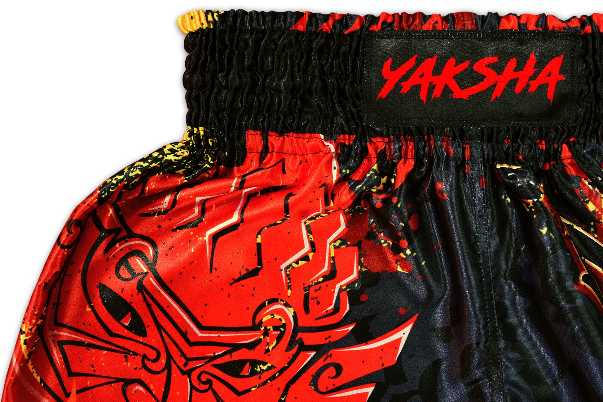 Detail of black satin hem and fire pattern stitching on YAKSHA Firestarter fight shorts