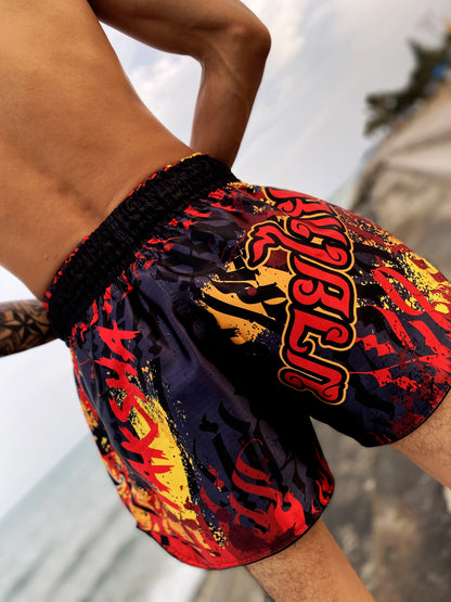 Fighter wearing YAKSHA Firestarter fight shorts outdoors, MUAY THAI lettering side panel visible
