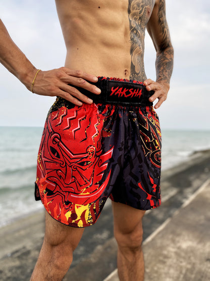 Fighter wearing YAKSHA Firestarter kickboxing shorts outdoors, red demon face panel facing forward