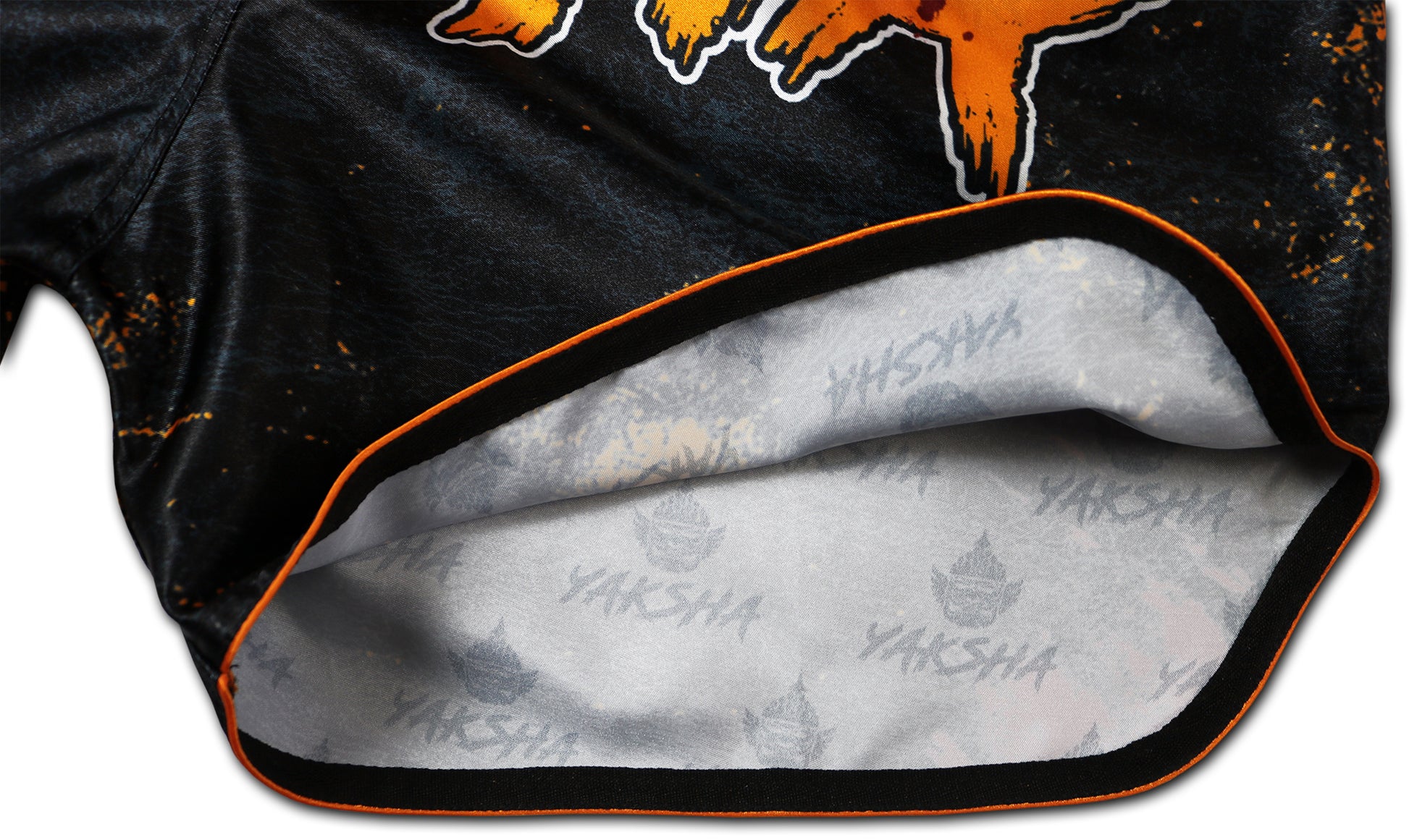 Detail of orange piping and inner YAKSHA print lining on the Grunge Black Orange Thai boxing shorts