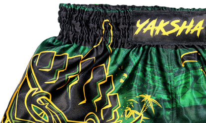 Close up of black elastic waistband with gold YAKSHA label and green satin fabric on Rumble in the Jungle Fight Shorts