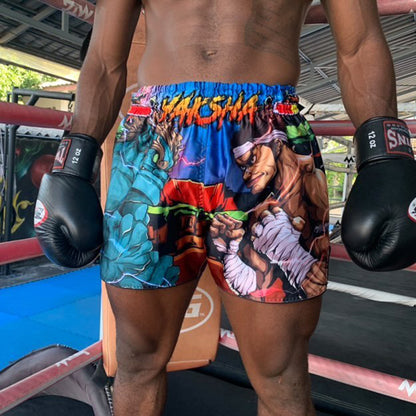 A Muay Thai fighter wearing black gloves and the YAKSHA Street Fighter shorts with anime warriors and electric lightning print inside a Muay Thai ring
