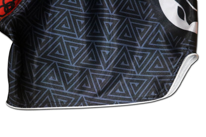 Detail of black geometric triangle pattern and white piping seam on BLACK PANTHER Adinkra fight shorts
