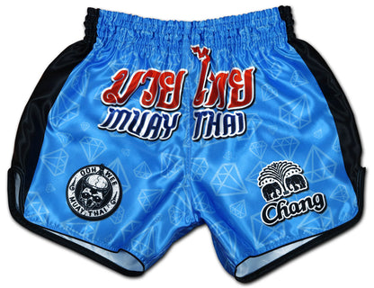 Blue Corner fight shorts front view, electric blue diamond satin with red Thai script, OOWEE skull badge and Chang elephant logo
