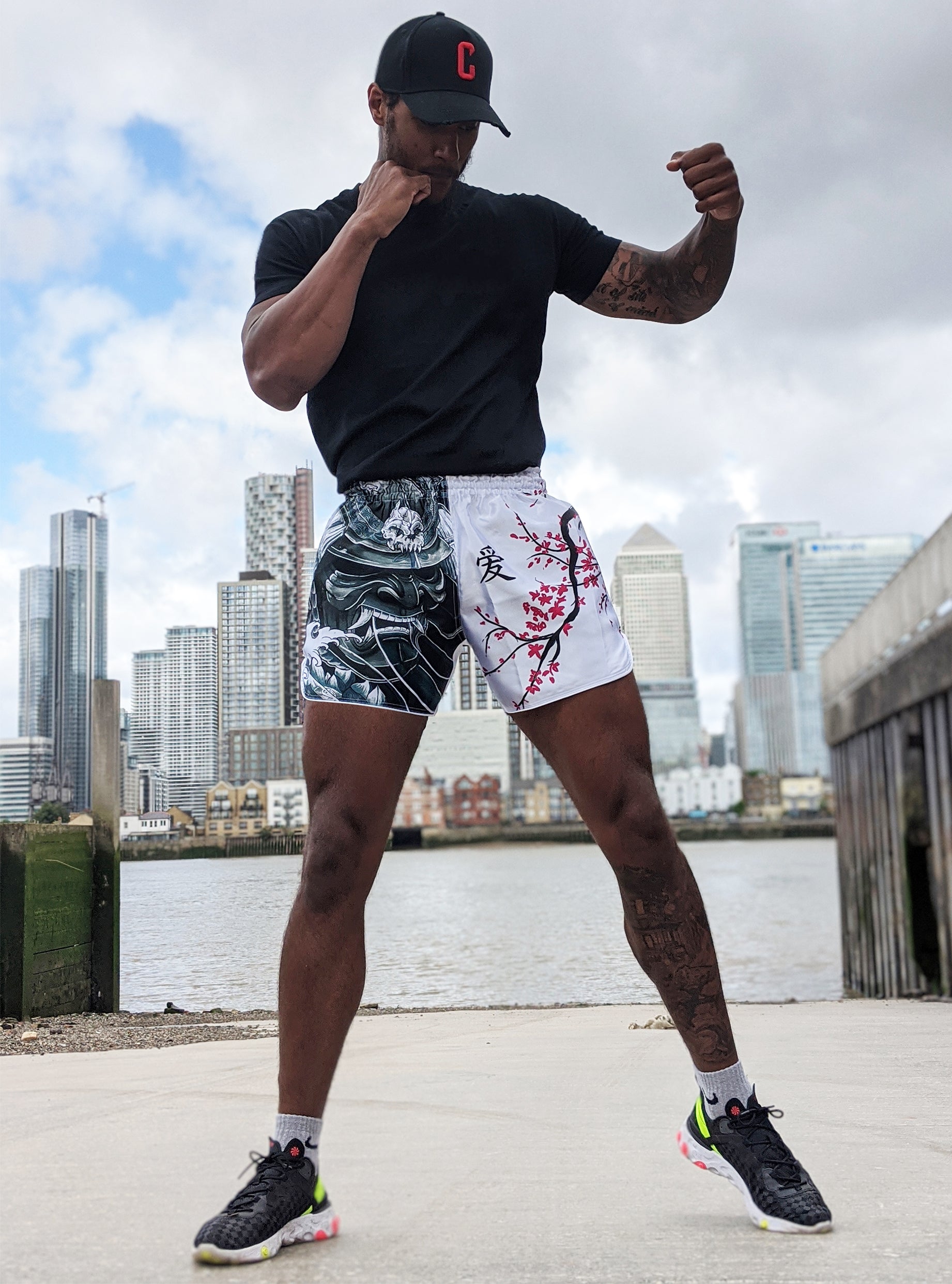 Male fighter wearing Cherry Blossom Samurai Thai fightwear shorts in front of the London skyline, showcasing the unisex fit and streetwear-ready style of the design