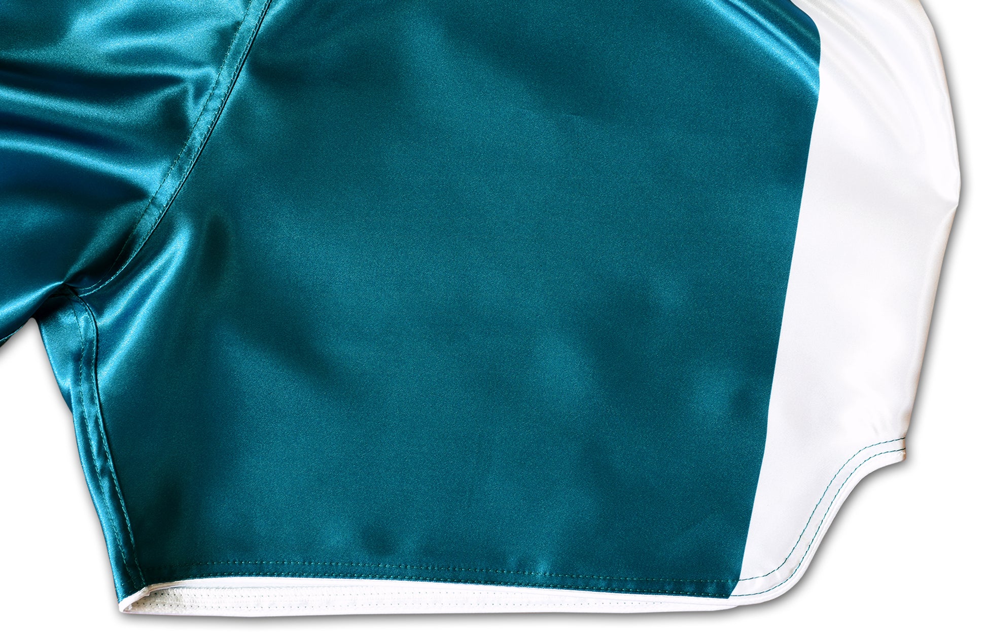 Detail of a Muay Thai training shorts with teal green satin fabric and white stitched border on the side slit