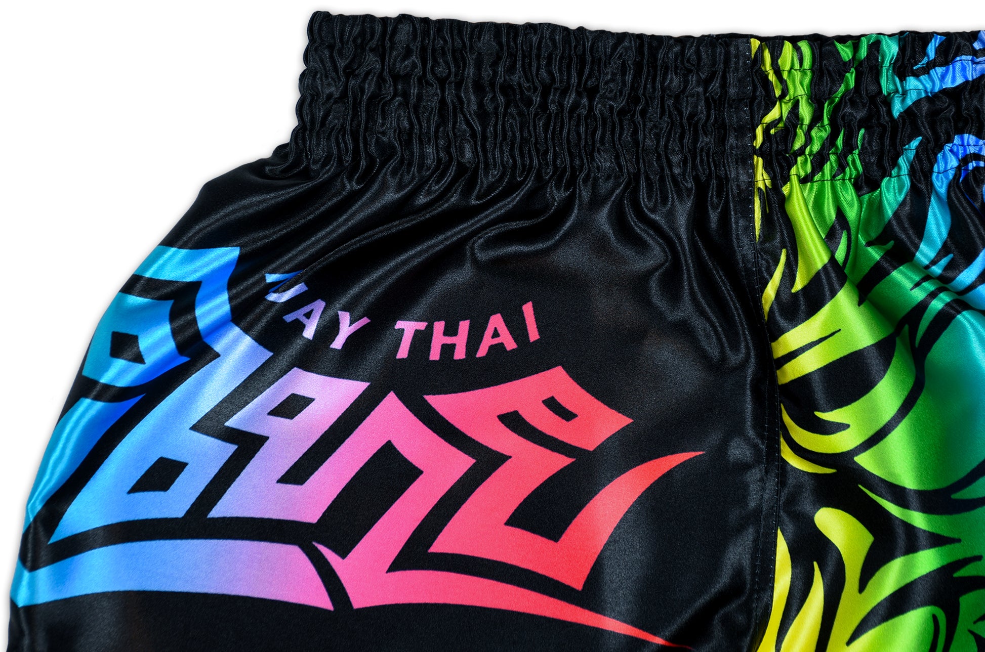 LGBTQ+ Muay Thai Boxing Shorts rainbow detail showing colorful Muay Thai script in full rainbow gradient on black satin