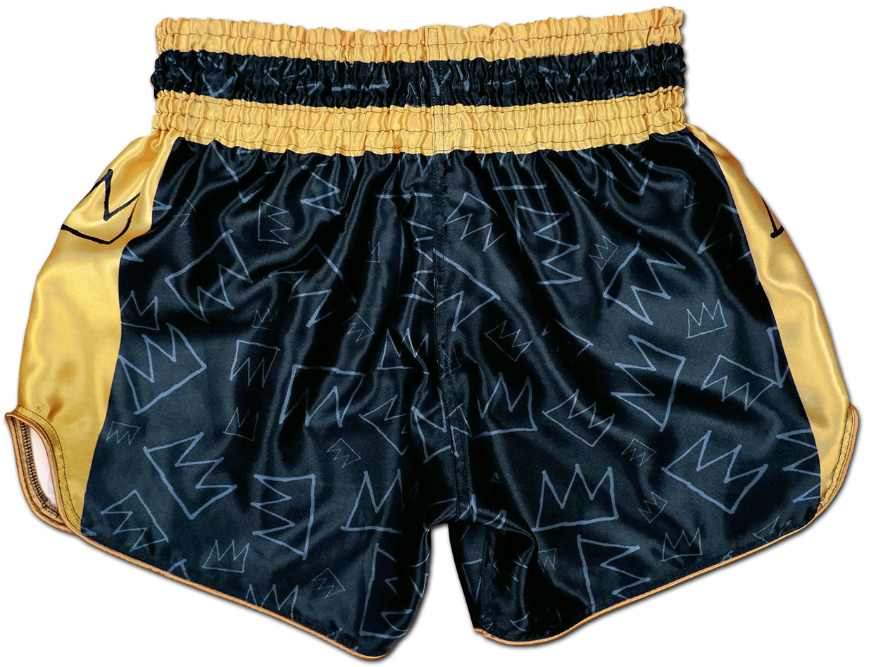 Back view of black and gold Muay Thai King boxing shorts with subtle hand drawn crown pattern across the satin fabric