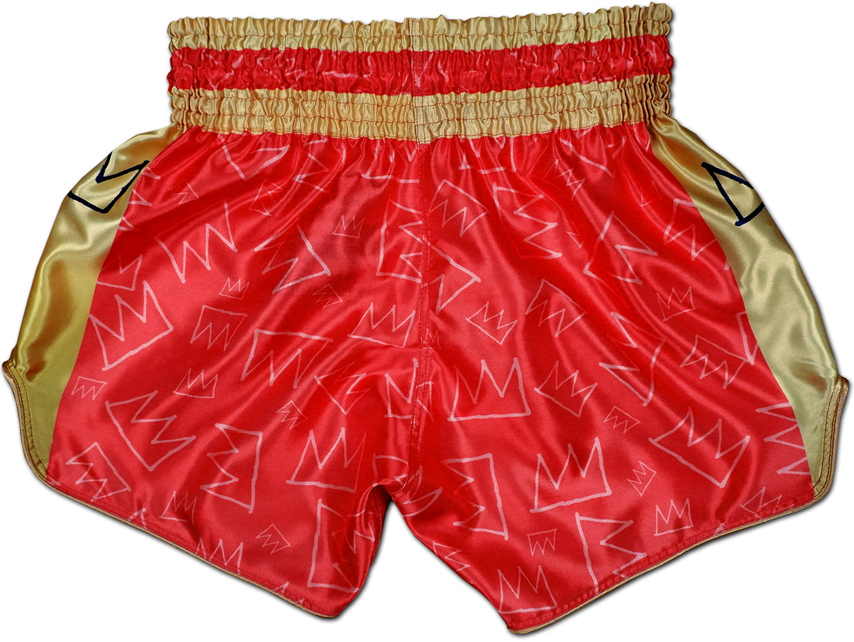 Back view of red and gold Muay Thai King boxing shorts with scattered hand drawn crown pattern across the satin fabric