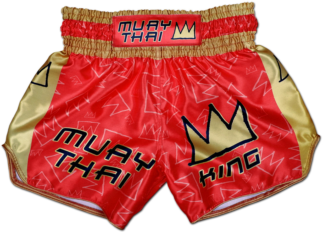 Front view of Muay Thai King boxing shorts in royal red satin with gold side panels and bold stitched KING crown logo