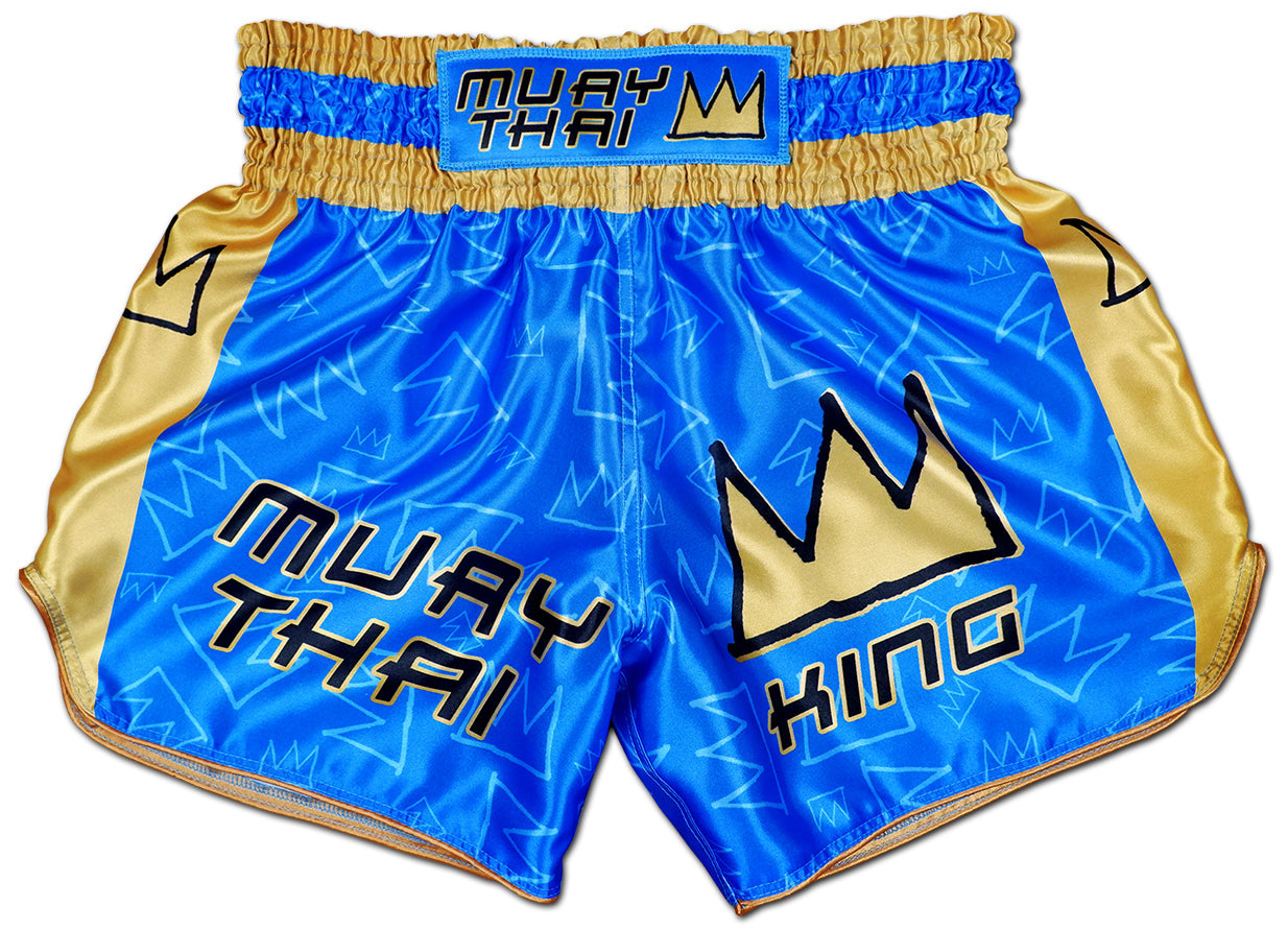 Front view of Muay Thai King Thaiboxing shorts in royal blue satin with gold side panels and stitched KING crown logo