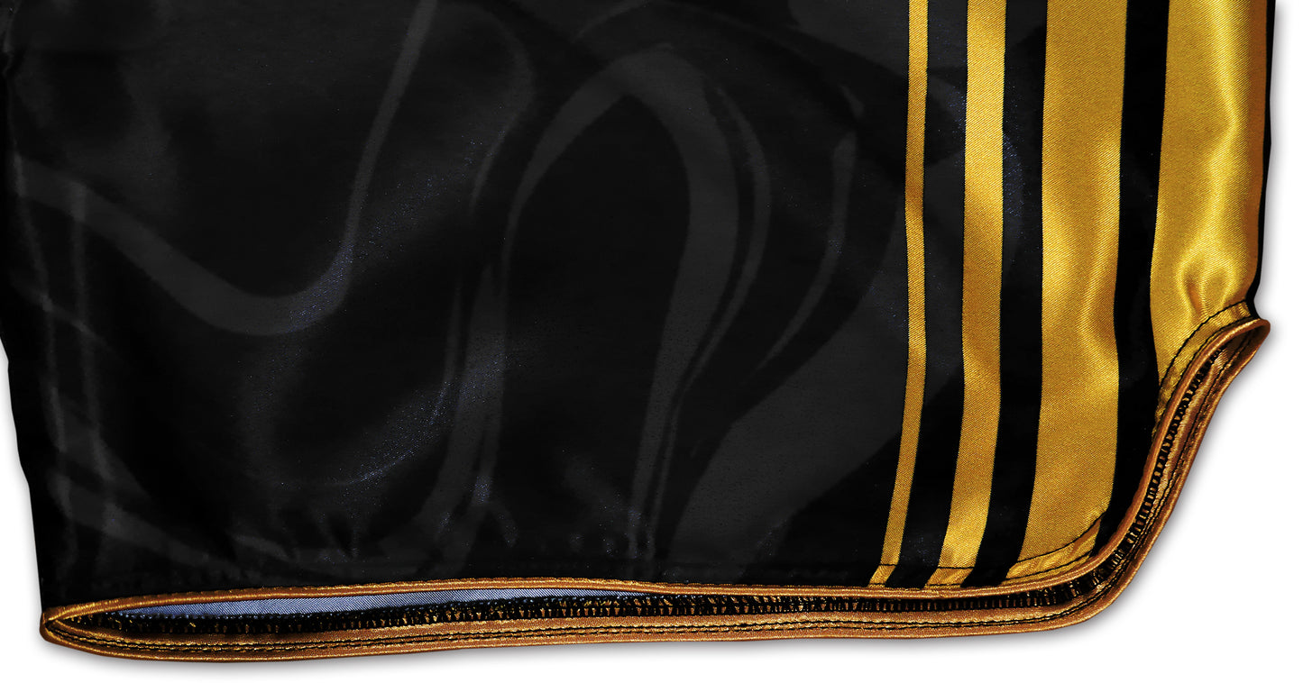 Kickboxing Shorts detail showing elaborately processed gold borders and gold stripes on black satin
