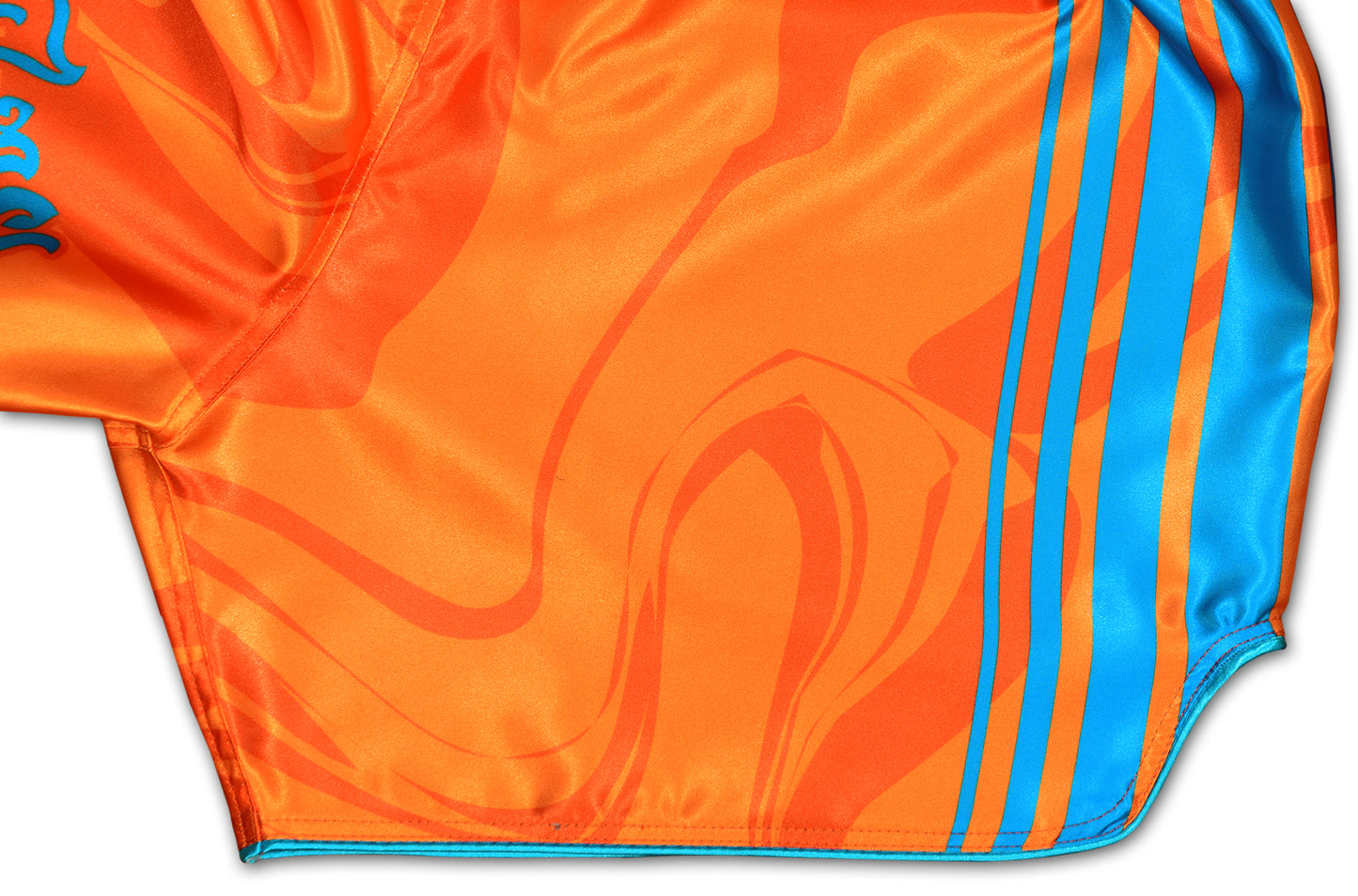 OOWEE Muay Thai Shorts detail showing blue stripes and smoke liquid design on vibrant orange premium satin