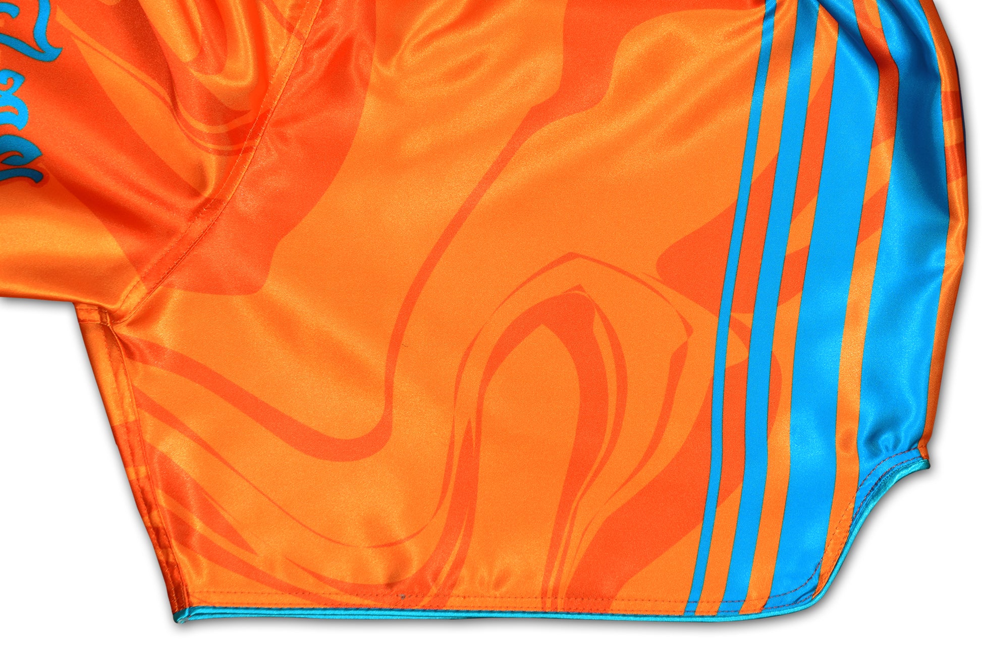 OOWEE Muay Thai Shorts detail showing blue stripes and smoke liquid design on vibrant orange premium satin