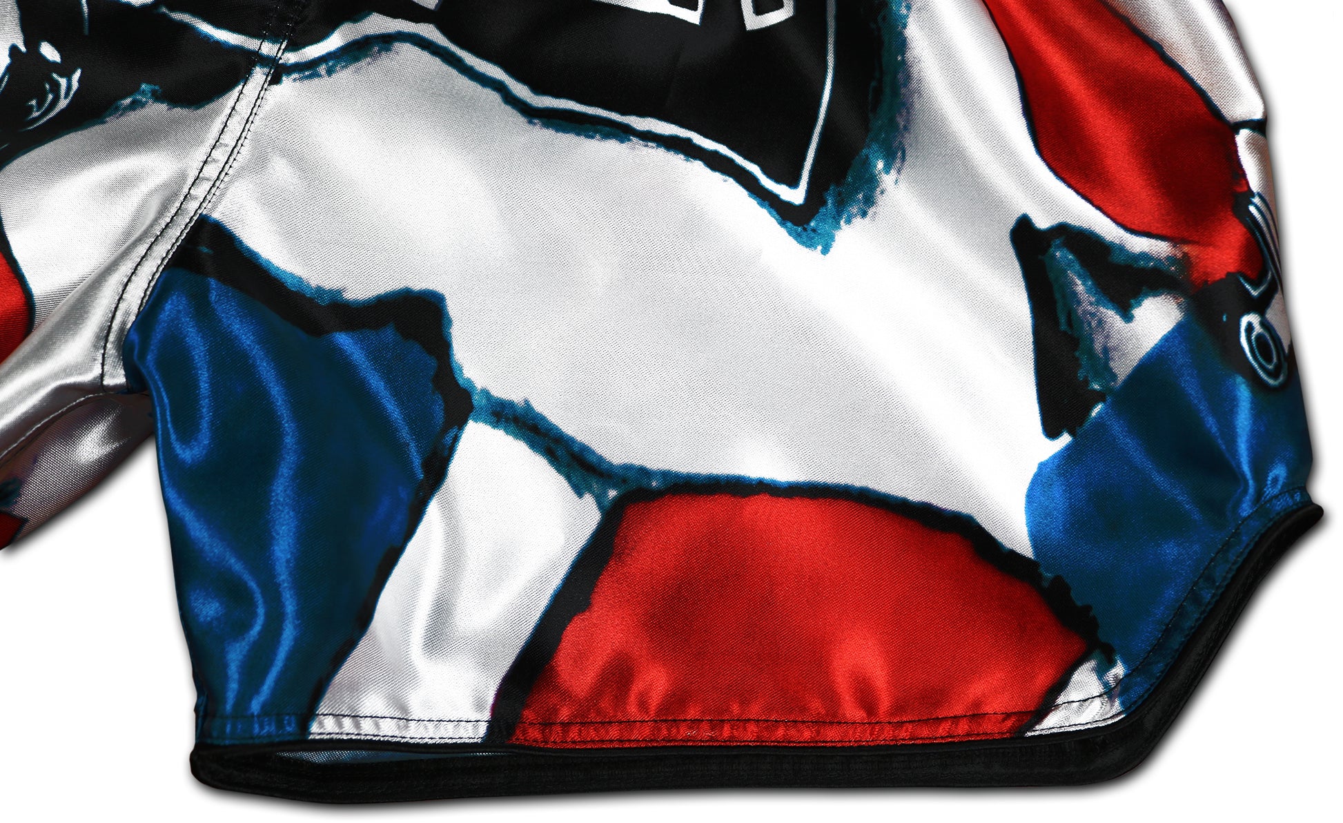 Patriot Muay Thai Shorts detail showing red white and blue satin fabric with reinforced seams and elaborately processed borders