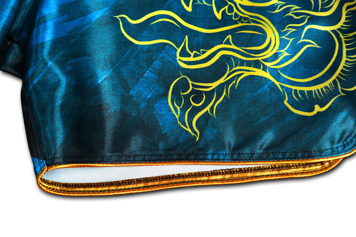 Detail of gold satin trim, reinforced stitching and gold Naga serpent print on Phaya Naga aqua blue Muay Thai Fight Shorts