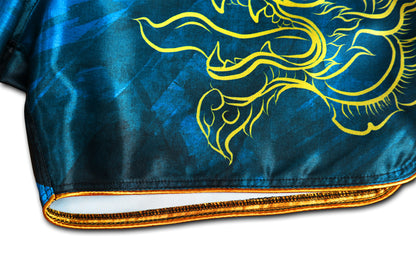 Detail of gold satin trim, reinforced stitching and gold Naga serpent print on Phaya Naga aqua blue Muay Thai Fight Shorts