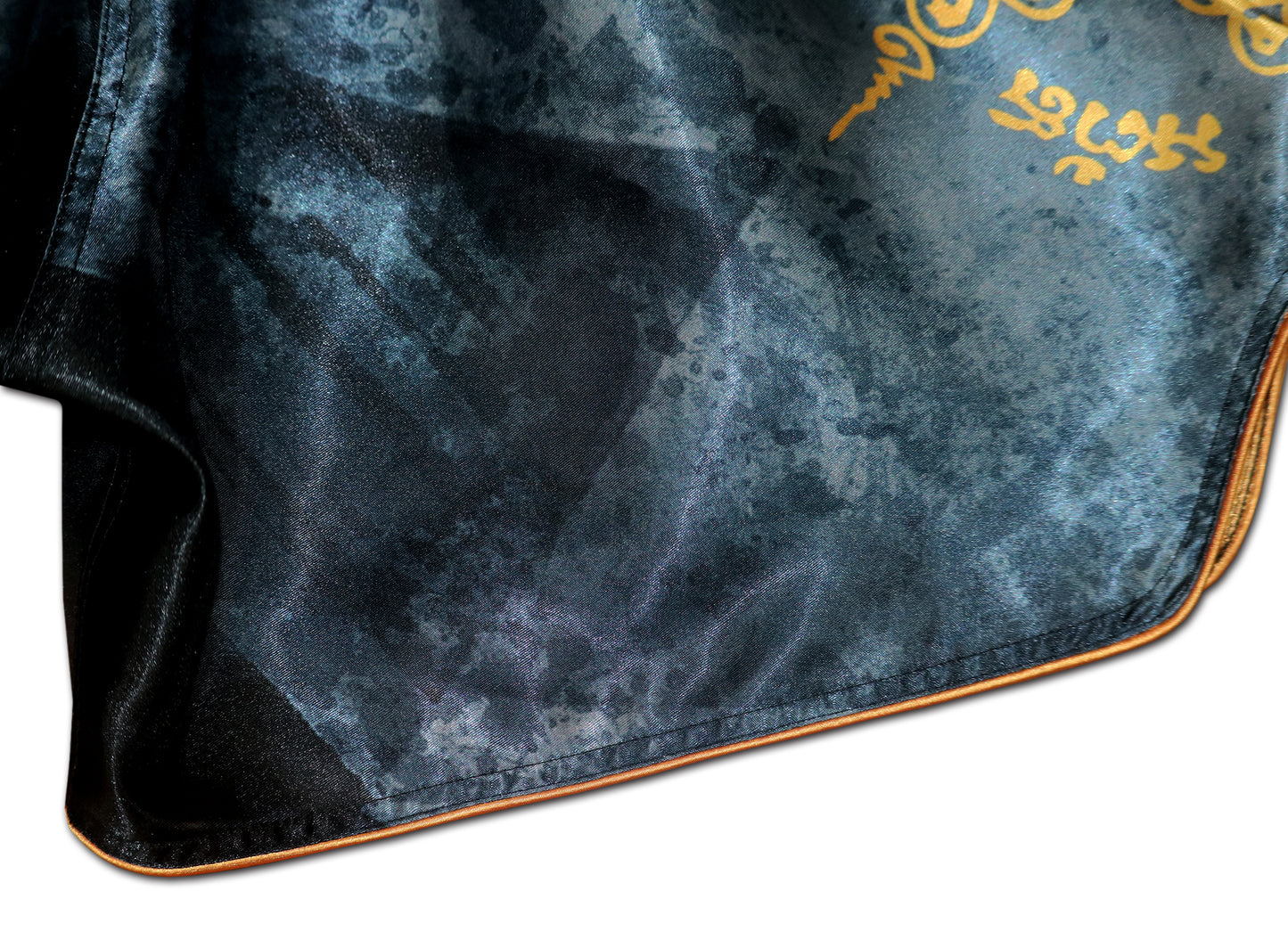 Close up of black elastic waistband and gold Sak Yant sacred Thai script on Phaya Naga fight shorts in black satin
