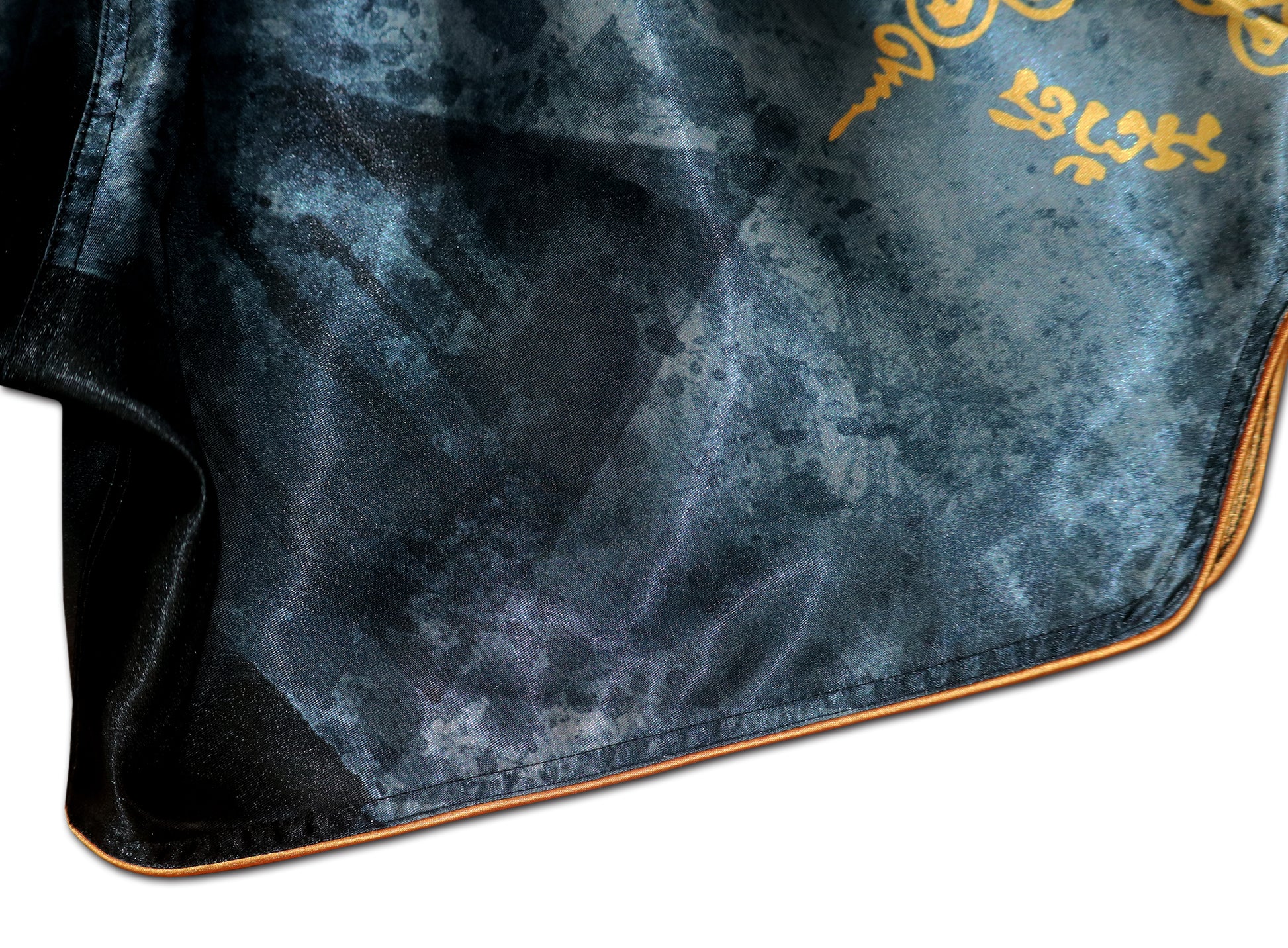 Close up of black elastic waistband and gold Sak Yant sacred Thai script on Phaya Naga fight shorts in black satin
