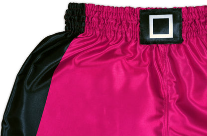 Close up of glossy pink satin fabric and black waistband with a white square on Pink Soldier fight shorts