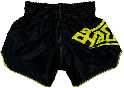 Back view of black satin Thai fightwear shorts with bold yellow tribal lettering and contrast yellow stitching along the hem