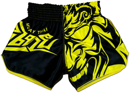 Front view of black and yellow Tribal Samurai Thai boxing shorts featuring a bold yellow oni demon mask graphic and sharp tribal lettering on glossy satin fabric