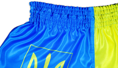 Close-up of glossy satin texture and elastic waistband on blue and yellow Ukraine Fight Shorts