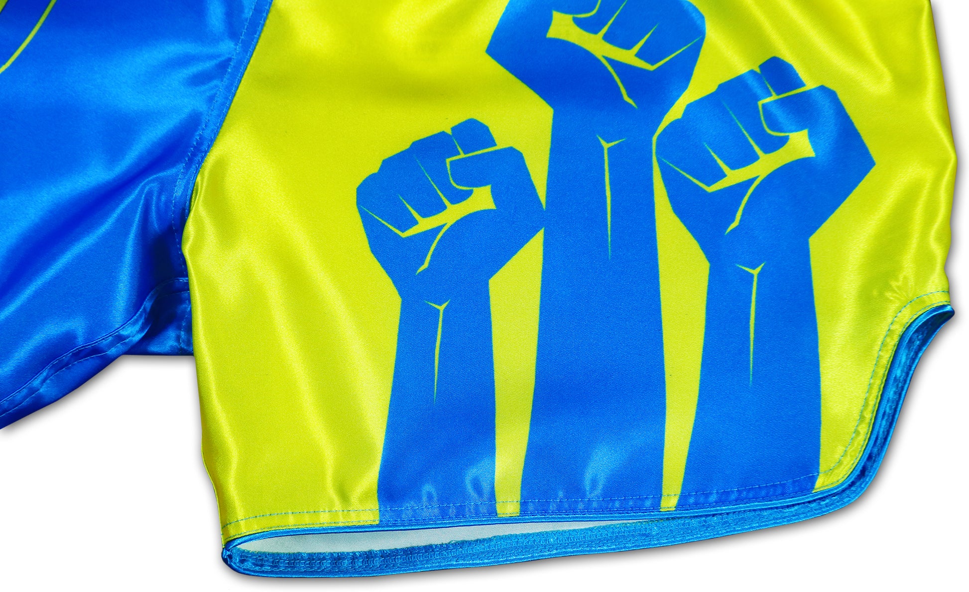 Detailed view of blue resistance fist artwork printed on yellow satin Ukraine Fight Shorts