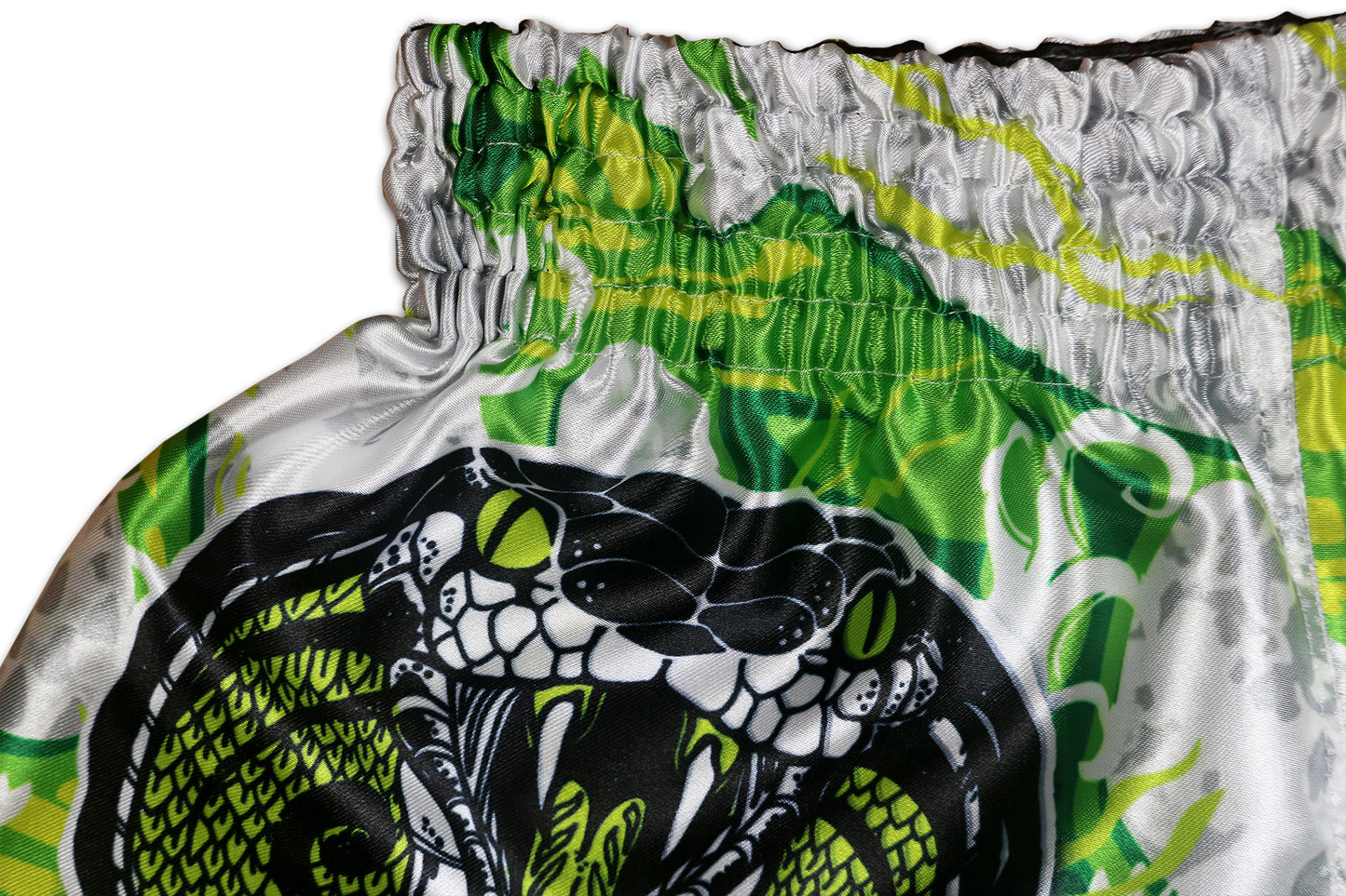 White Cobra Muay Thai Boxing Shorts detail - bold cobra artwork with poison green eyes, premium sublimation print