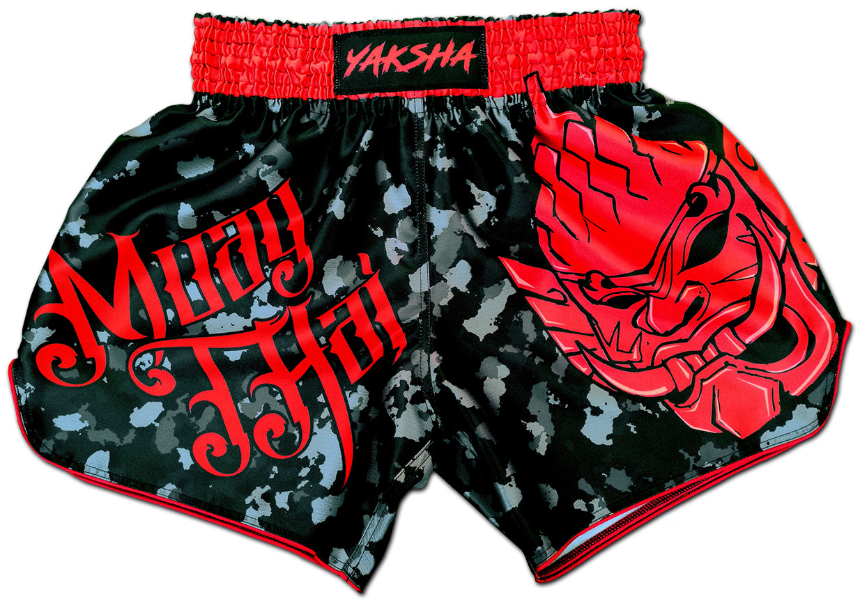 YAKSHA Black Red Camouflage fightshorts front view, red oni demon print and Muay Thai calligraphy on black digital camo satin